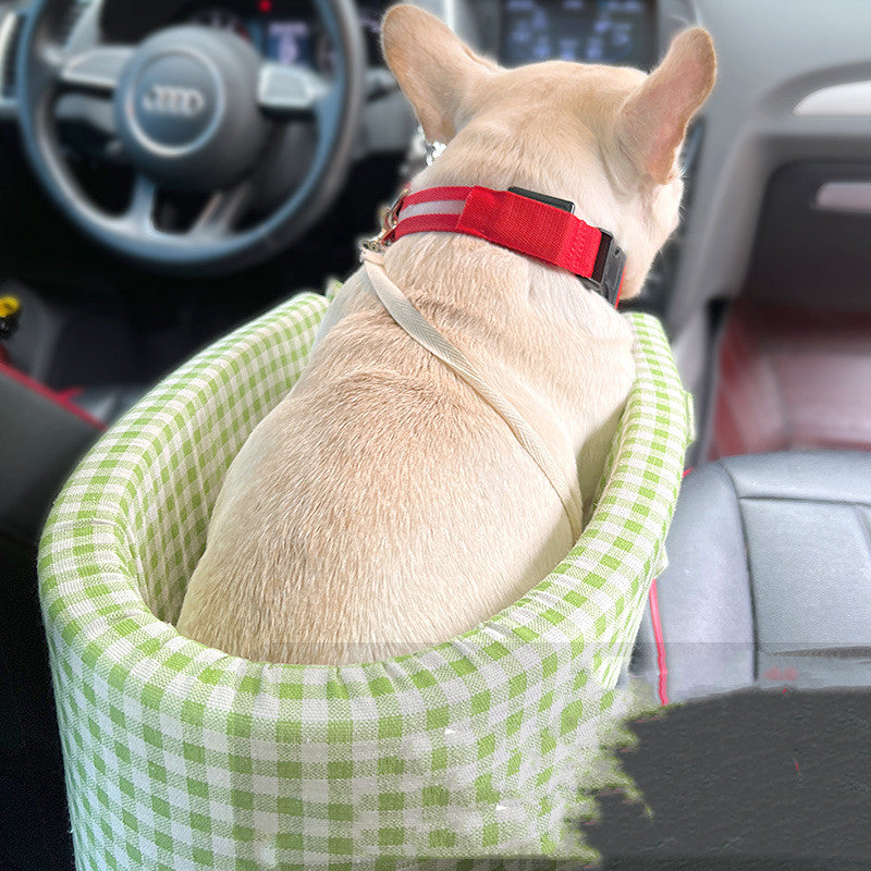 グリーンの車用ペットベッドに後ろ向きで座る小型犬
